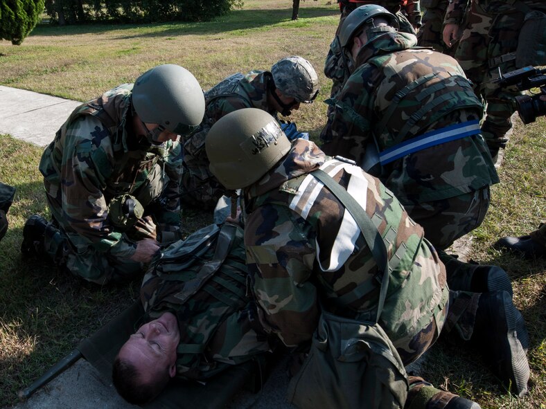 Col. Ken "Wolf" Ekman, 8th Fighter Wing commander, is treated for simulated serious injuries by 8th Medical Group personnel before being transported to the alternate medical facility during Exercise Beverly Midnight 15-1, Oct. 22, 2014. The Wolf Pack’s medical group reacted to a simulated explosion at the primary facility, forcing them to flex to an alternate location while simultaneously treating critical injuries. (U.S. Air Force photo by Senior Airman Katrina Heikkinen/Released)
