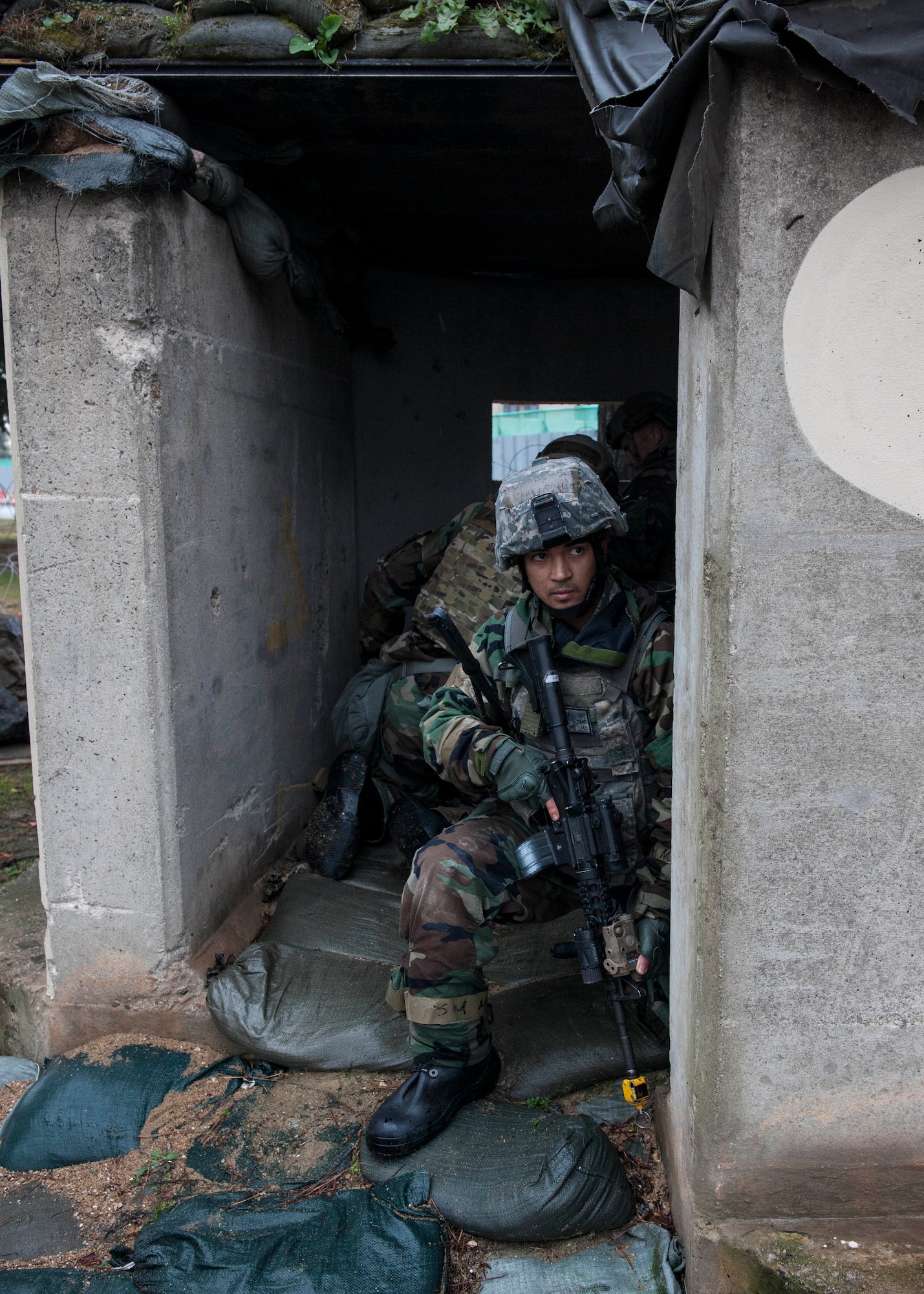 Airman 1st Class Ronaldo Cruz, 8th Security Forces Squadron response force member, provides security at an entry control point during Exercise Beverly Midnight 15-1, Kunsan Air Base, Republic of Korea, Oct. 21, 2014. Cruz guarded the area as four defenders donned chemical, biological, radiological and nuclear protective gear. The four-day exercise demonstrated the Wolf Pack's ability to work alongside Republic of Korea air force allies as well as their capability of responding to wartime and armistice threats. (U.S. Air Force photo by Senior Airman Katrina Heikkinen/Released)