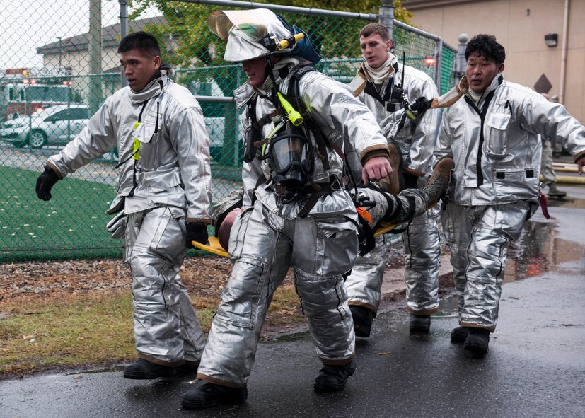 Airmen from the 8th Civil Engineer Squadron fire department carry a Republic of Korea air force member suffering from simulated injuries following a mass casualty event at the Kunsan Air Base food court during Exercise Beverly Midnight 15-1, Oct. 20, 2014. The four-day exercise demonstrated the Wolf Pack's ability to work alongside ROKAF allies, as well as their capability of responding to wartime and armistice threats. (U.S. Air Force photo by Senior Airman Katrina Heikkinen/Released)