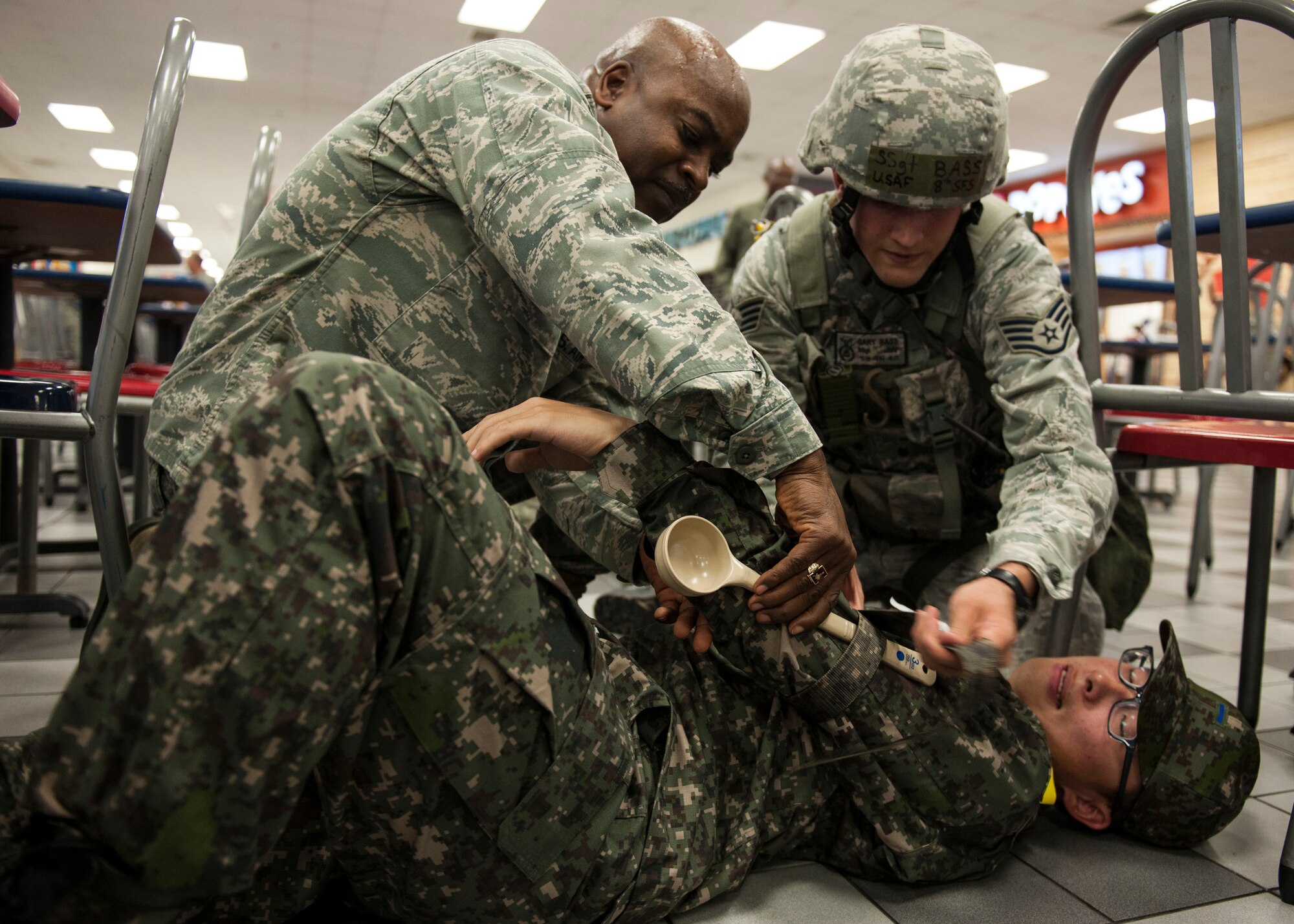 Chaplain (Maj.) Dwayne "Shepherd" Jones, 8th Fighter Wing head chaplain (left), and Staff Sgt. Gary Bass, 8th Security Forces Squadron member, apply a temporary splint for a Republic of Korea air force member who suffered from a simulated forearm fracture following an IED explosion during Exercise Beverly Midnight 15-1, Kunsan Air Base, Republic of Korea, Oct. 20, 2014. The four-day exercise demonstrated the Wolf Pack's ability to work alongside Republic of Korea air force allies as well as their capability of responding to wartime and armistice threats. (U.S. Air Force photo by Senior Airman Katrina Heikkinen/Released)