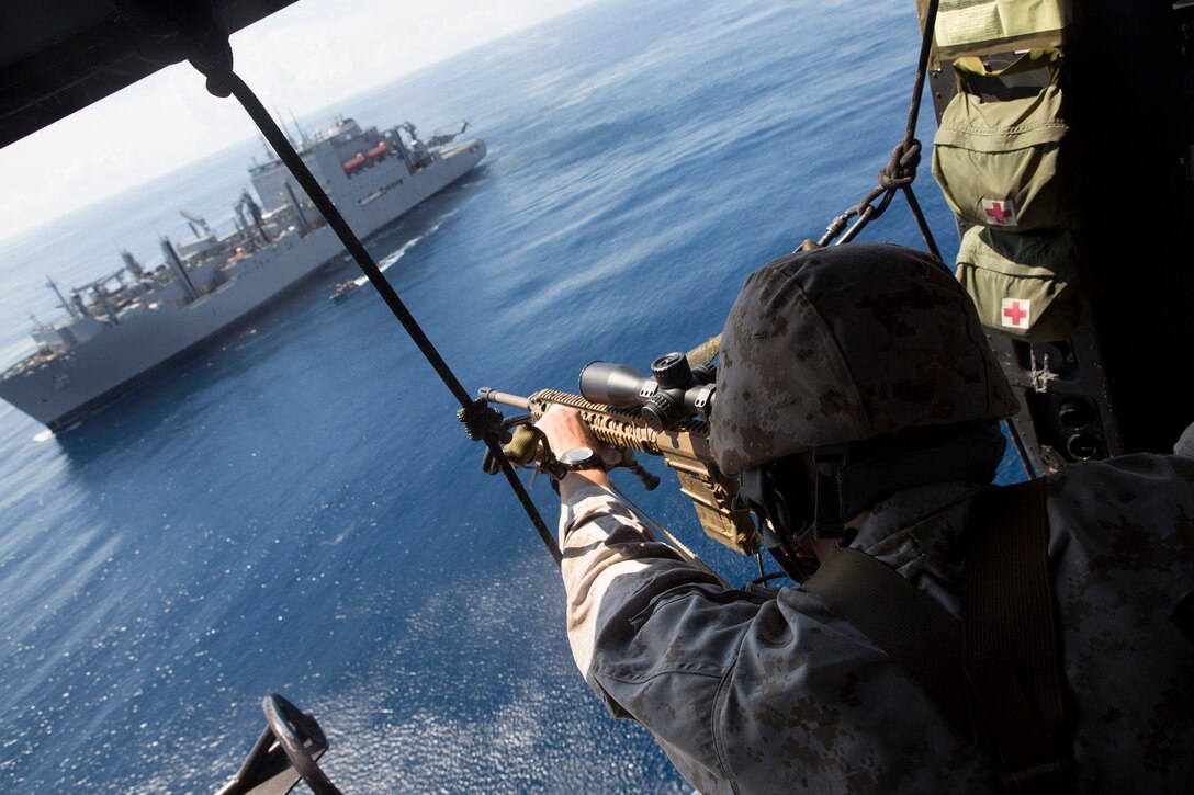 Corporal Phillip Lilly II, a chief scout with Scout Sniper Platoon, Battalion Landing Team, 3rd Battalion, 6th Marine Regiment, 24th Marine Expeditionary Unit, provides security for Marines aboard a notional hostile ship, at sea, Sept. 16, 2014. The Marines conducted a Visit, Board, Search and Seizure exercise during Amphibious Ready Group/ Marine Expeditionary Unit Exercise, which spans over the majority of September.