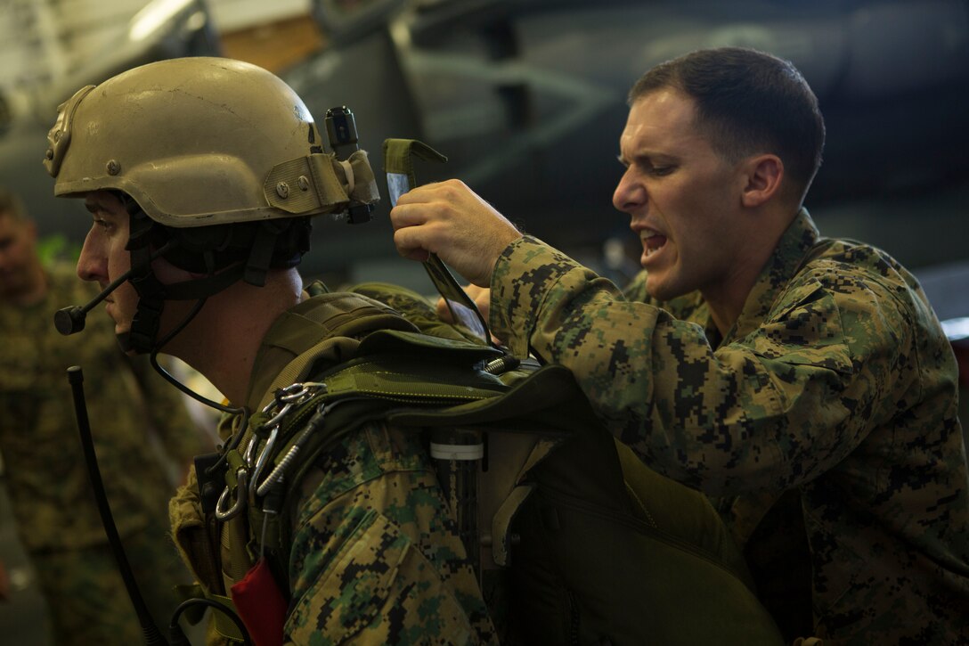 The 24th Marine Expeditionary Unit’s Maritime Raid Force Marines get their parachute packs checked during Amphibious Ready Group/Marine Expeditionary Unit Exercise aboard the USS Iwo Jima, at sea, Sept. 11, 2014. The Marines with the MRF conducted a Reconnaissance and Surveillance exercise inserting by air.  