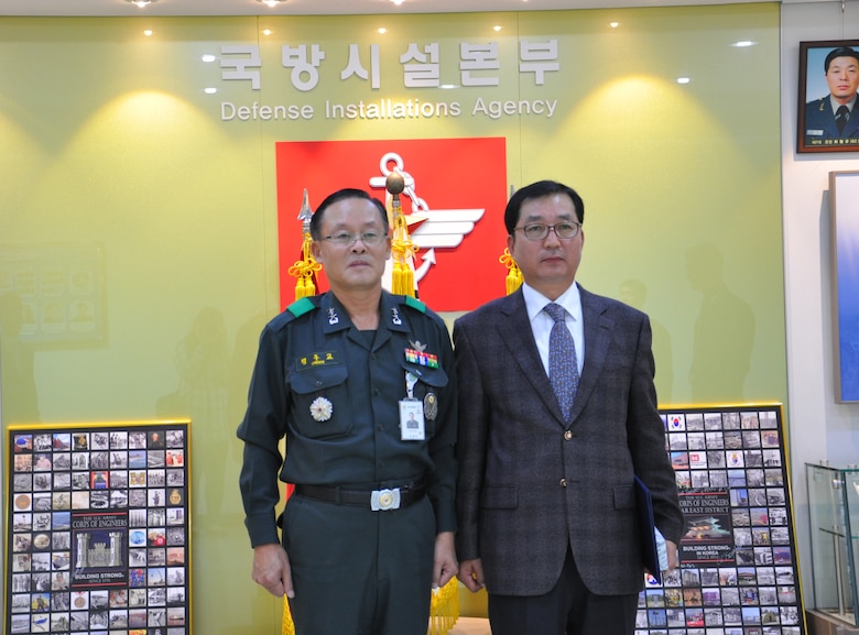 Republic of Korea Maj. Gen. Chung Joo Kyo, commander of the Ministry of National Defense-Defense Installations Agency presents a certificate of commendation to Chang U-ik, Humphreys area office safety and occupational health specialist.