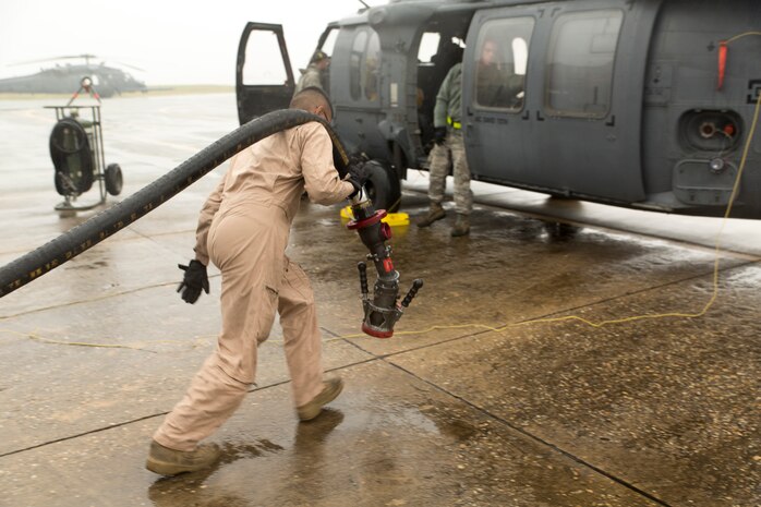 Cpl. Eduardo Bahena, a semitrailer refueler operator with Marine Wing Support Squadron 171, carries a hose to refuel an HH-60G Pave Hawk during the Korean Marine Exchange Program 14-13, Oct. 20, 2014, on Osan Air Base, Republic of Korea. The program’s goals are to increase the combat readiness of Marine Aircraft Group 12, improve its operating skills as a Marine Air-Ground Task Force and enhance joint and combined integration with the U.S. Air Force and ROK Marine Corps. KMEP 14-13 is a multinational exercise that focuses on the integration of aviation and ground assets within the construct of a traditional Combined Arms Live Fire Exercise. Supporting assets include, but are not limited to, Marine Aviation Logistics Squadron 12 and MWSS-171.