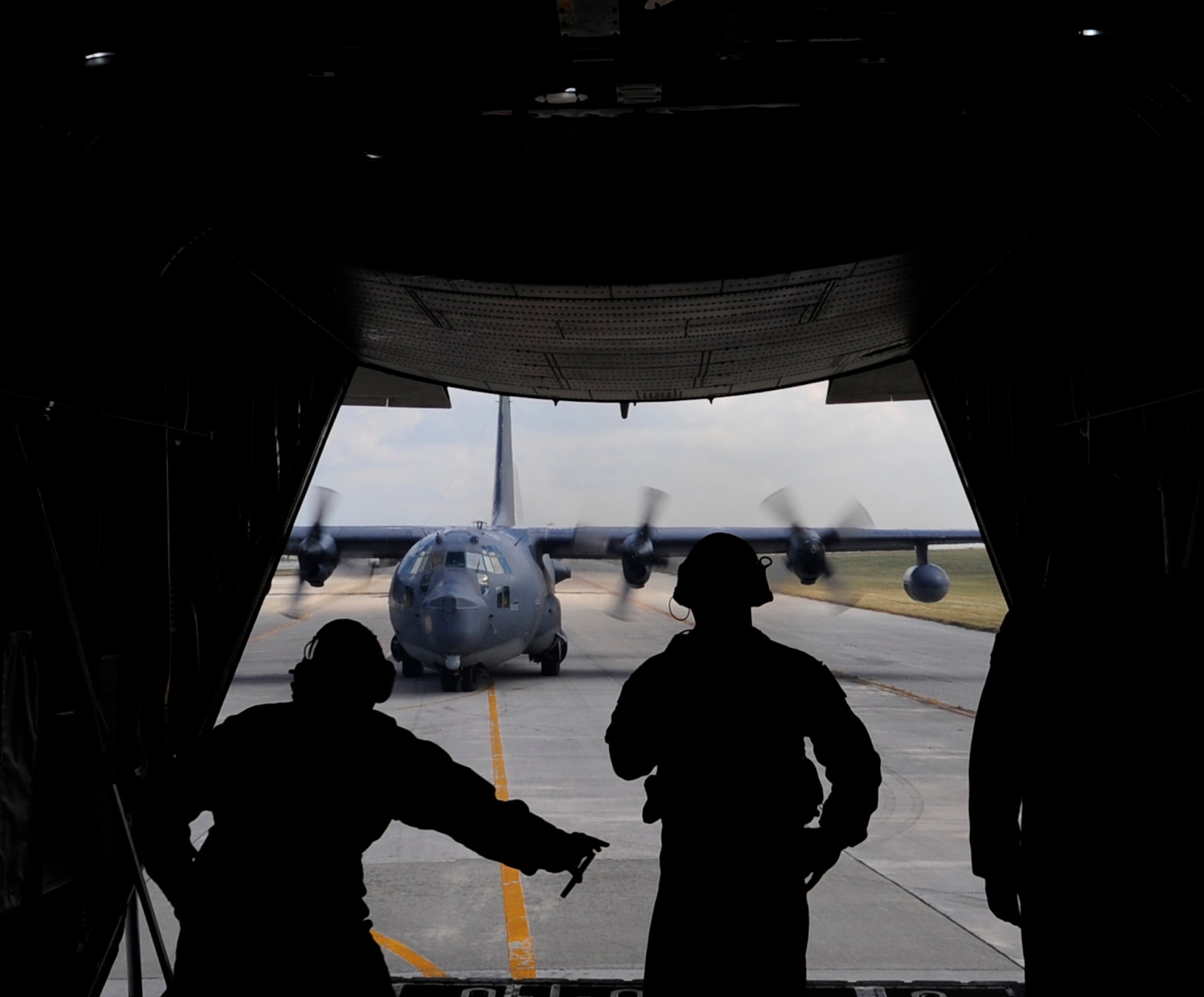 Loadmasters from the 17th Special Operations Squadron monitor an MC-130P Combat Shadow during taxi into a parking spot in sequence with three other MC-130P Combat Shadow aircraft on the flight line of Kadena Air Base, Japan, Oct. 16, 2014. The MC-130P Combat Shadow crew consists of two pilots, two navigators, a flight engineer, a communications systems operator and two loadmasters. (U.S. Air Force photo by Airman 1st Class Keith James)