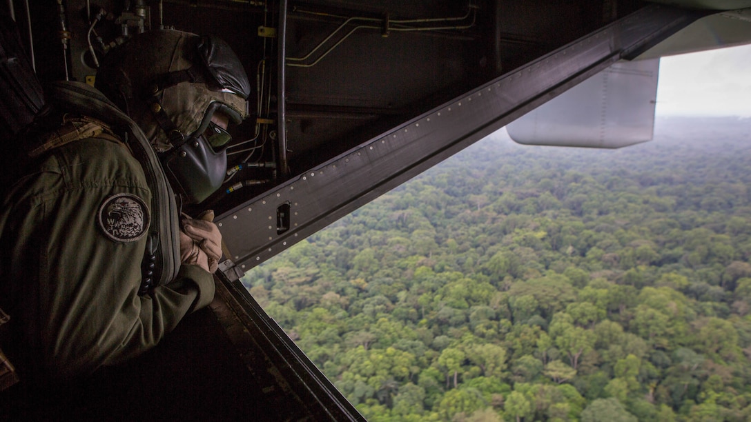A U.S. Marine with Special-Purpose Marine Air-Ground Task Force - Crisis Response - Africa looks out of an MV-22B Osprey while conducting an aerial reconnaissance of Liberia in support of Operation United Assistance in Oct. 11, 2014. Operation United Assistance is part of a comprehensive U.S. Government effort, led by the U.S. Agency for International Development, to respond to and contain the outbreak of the Ebola virus in West Africa as quickly as possible. 