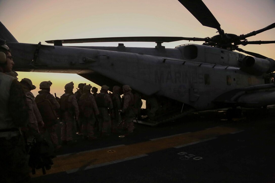 Marines with Golf Company, Battalion Landing Team 2nd Battalion, 1st Marines, 11th Marine Expeditionary Unit (MEU), practice boarding a CH-53E Super Stallion, assigned to Marine Medium Tiltrotor Squadron 163 (Reinforced), 11th MEU, on the flight deck of amphibious assault ship USS Makin Island (LHD 8), during a recurring, regularly scheduled quick reaction force rehearsal, Oct. 25. The Makin Island Amphibious Ready Group (ARG) and the embarked 11th MEU provide a versatile, sea-based, expeditionary force that can be tailored to a variety of missions in the U.S. 5th Fleet area of responsibility. (U.S. Marine Corps photo by Cpl. Laura Y. Raga/Released)