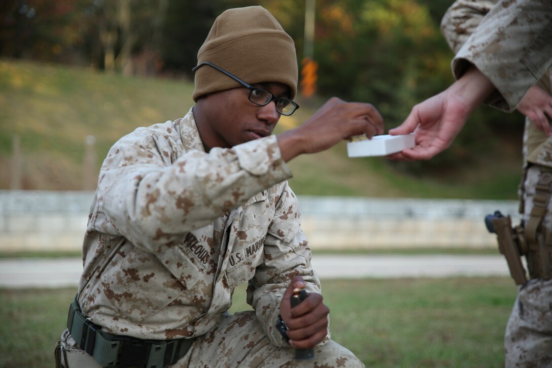 Lance Cpl. Keven Saint Louis, a marksmanship student at the Combat Marksmanship Coaches Course, loads rounds into a magazine during the pre-qualification course of fire at the Marksmanship Training Unit, Weapons Training Battalion in Quantico, Va., Oct. 24, 2014. This particular CMC course was staffed entirely by Reserve Marines from the Marine Corps Reserve Shooting Team, who are the top competitive shooters in the Marine Corps Reserve.