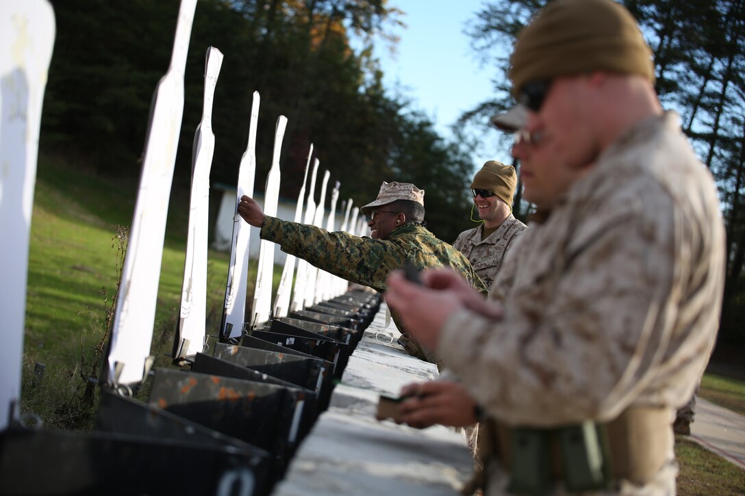 Lance Cpls. James Leiter and Christopher Robeson score and repair a target during the combat pistol program pre-qualification at the Combat Marksmanship Coaches Course at the Marksmanship Training Unit, Weapons Training Battalion in Quantico, Va., Oct. 24, 2014. This particular CMC course was staffed entirely by Reserve Marines from the Marine Corps Reserve Shooting Team, who are the top competitive shooters in the Marine Corps Reserve.