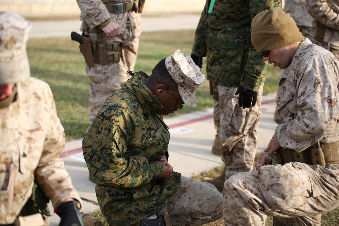 Lance Cpl. James Leiter (right) helps fellow marksmanship student Lance Cpl. Christopher Robeson (left) load magazines for the next round of fire during the combat pistol program qualification at the Combat Marksmanship Coaches Course at the Marksmanship Training Unit, Weapons Training Battalion in Quantico, Va., Oct. 24, 2014. This particular CMC course was staffed entirely by Reserve Marines from the Marine Corps Reserve Shooting Team, who are the top competitive shooters in the Marine Corps Reserve.