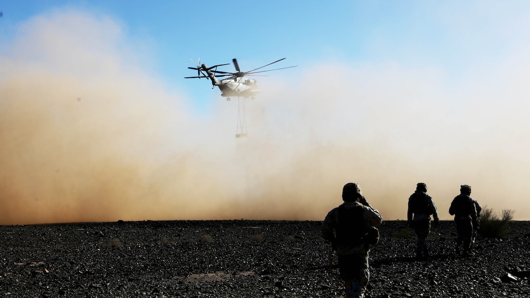 Marines with Combat Logistics Battalion 13 watch as a CH-53E Super Stallion with Marine Heavy Helicopter Squadron 462 carries simulated cargo during a training exercise aboard Marine Corps Air Station Yuma, Ariz., Oct. 23. The training allows Marines to be mission ready and prepared to respond at a moment’s notice.
