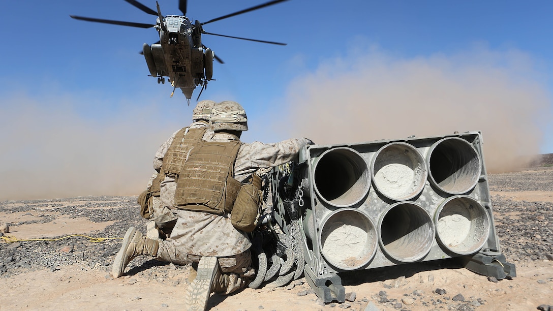Marines with Combat Logistics Battalion 13 wait as a CH-53E Super Stallion with Marine Heavy Helicopter Squadron 462 prepares to lift a decommissioned rocket pod aboard Marine Corps Air Station Yuma, Ariz., Oct. 23. The training helped the Marines experience the effects of the aircraft while trying to attach the cargo.