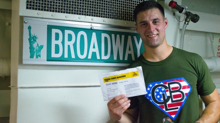 First Lt. Thomas Heemer, the logistics officer for Combat Logistics Battalion 24, 24th Marine Expeditionary Unit, poses with his Marine Corps Marathon bib on “Broadway,” a passageway aboard the USS New York, Oct. 26, 2014. Due to pre-deployment training with the 24th MEU, Heemer ran the MCM on a treadmill aboard the New York, finishing under the four-hour mark. The 24th MEU is conducting its final pre-deployment training exercise before a deployment at the end of the year.