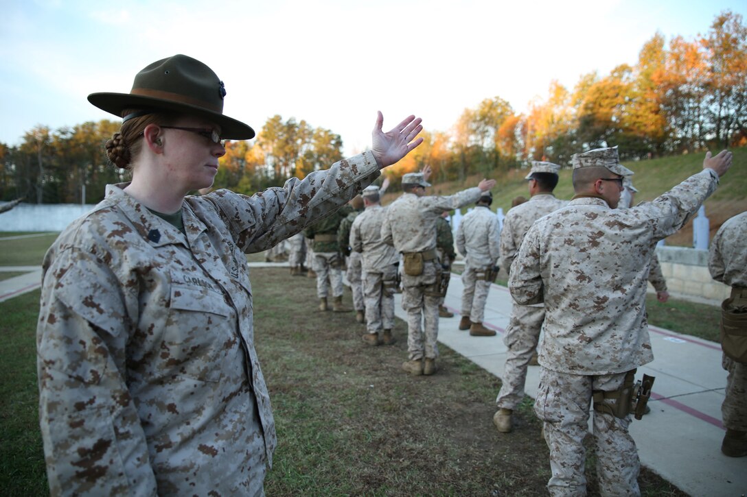 Master Sgt. Julia Carlson relays the signal that the line is ready to fire at the Reserve Combat Marksmanship Coaches Course, Oct. 24, 2014 at Weapons Training Battalion in Quantico, Va.  Carlson, a marksmanship instructor and competitive shooter with the Marine Corps Reserve Shooting Team, is one of only four women in civilian and military competitive shooting history that is double-distinguished with both the rifle and pistol.