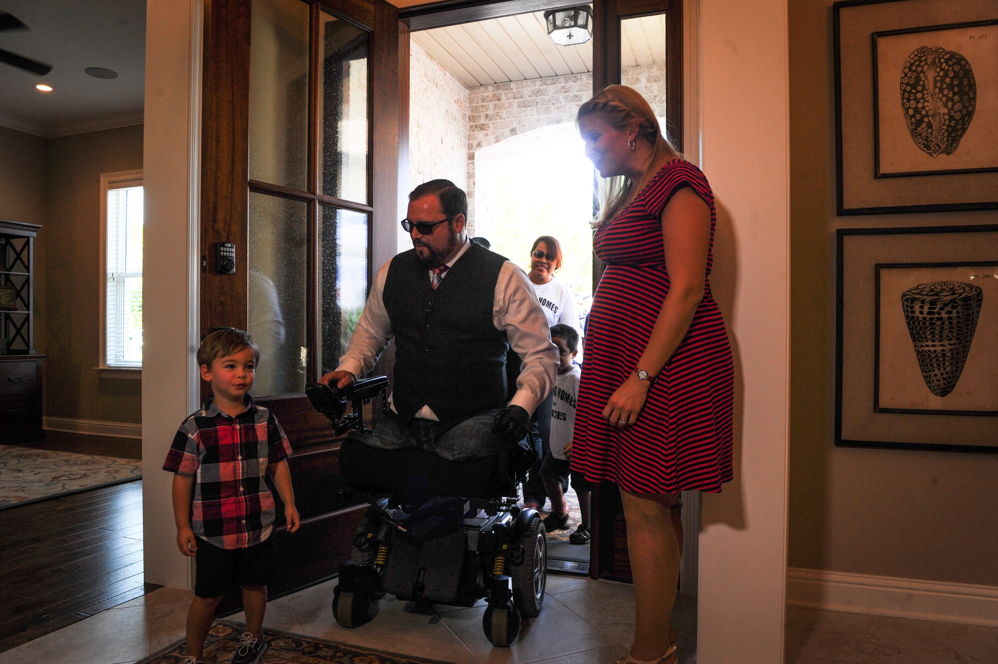 Joe Deslauriers, a retired Air Force Master Sgt., his wife Lisa and son Cameron, step into their new home for the first time in Destin, Fla., Oct. 25, 2014. Building Homes for Heroes gifted the mortgage-free home to the Deslauriers family during a patriotic welcome home ceremony. (U.S. Air Force photo/Senior Airman Christopher Callaway) 