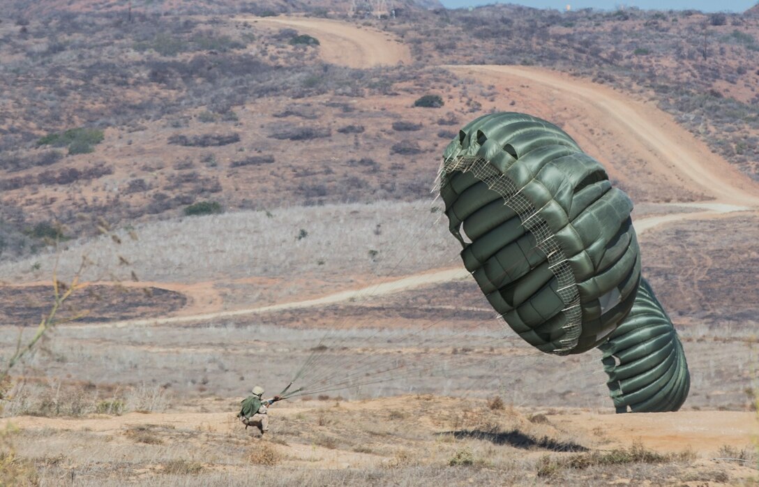 A U.S. Marine with Force Reconnaissance Detachment, 15th Marine Expeditionary Unit, retrieves his parachute during airborne-sustainment training aboard Camp Pendleton, Calif., Oct. 21, 2014. The Force Recon Detachment is scheduled to deploy with the 15th MEU next spring. (U.S. Marine Corps photo by Sgt. Emmanuel Ramos/Released)
