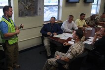 DoD personnel participate in an operations brief during Exercise Vigilant Response 2014 (VR14) aboard Marine Corps Air Station New River, N.C., Oct. 7, 2014.  VR14 is a two-day exercise designed to test the ability to conduct command and control measures in response to a pandemic outbreak aboard the Air Station.