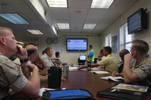 DoD personnel participate in an operations brief during Exercise Vigilant Response 2014 (VR14) aboard Marine Corps Air Station New River, N.C., Oct. 7, 2014.  VR14 is a two-day exercise designed to test the ability to conduct command and control measures in response to a pandemic outbreak aboard the Air Station.