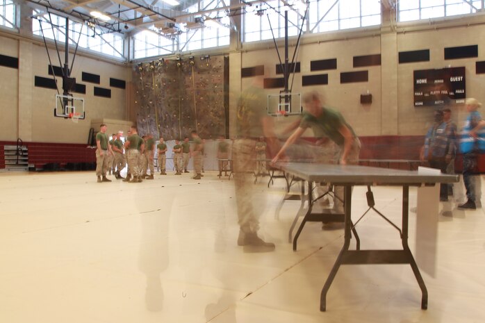 U.S. Service members set up tables during Exercise Vigilant Response 2014 (VR14) aboard Marine Corps Air Station New River, N.C., Oct. 7, 2014.  VR14 is a two-day exercise designed to test the ability to conduct command and control measures in response to a pandemic outbreak aboard the Air Station.