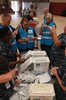 DoD personnel and U.S. Sailors prepare vaccinations during Exercise Vigilant Response 2014 (VR14) aboard Marine Corps Air Station New River, N.C., Oct. 7, 2014. VR14 is a two-day exercise designed to test the ability to conduct command and control measures in response to a pandemic outbreak aboard the Air Station.