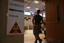 A U.S. Marine enters the vaccination area during Exercise Vigilant Response 2014 (VR14) aboard Marine Corps Air Station New River, N.C., Oct. 7, 2014.  VR14 was a two-day exercise designed to test the ability to conduct command and control measures in response to a pandemic outbreak aboard the Air Station.