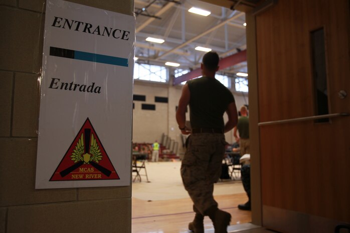 A U.S. Marine enters the vaccination area during Exercise Vigilant Response 2014 (VR14) aboard Marine Corps Air Station New River, N.C., Oct. 7, 2014.  VR14 was a two-day exercise designed to test the ability to conduct command and control measures in response to a pandemic outbreak aboard the Air Station.