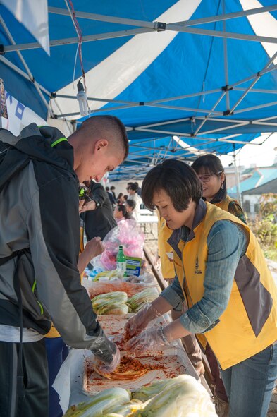 Airman 1st Class Chris O'Connor, 51st Logistics Readiness Squadron vehicle maintainer, learns how to make kimchi during the 11th Korean American Friendship Cultural Festival at the Songtan Entertainment District, Republic of Korea, Oct. 25, 2014. The festival helps both cultures to learn about the other. (U.S. Air Force photo by Senior Airman Matthew Lancaster)