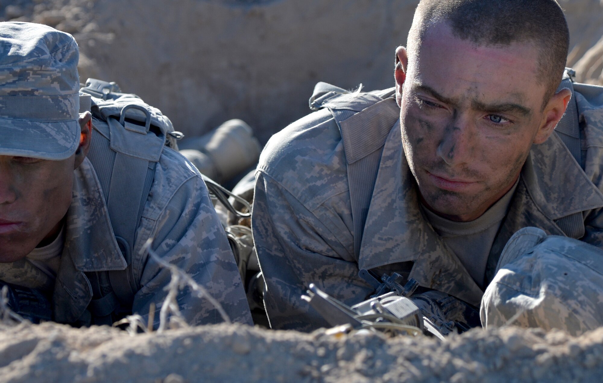 Senior Airman Franklin Sloat, 791st Missile Security Forces Squadron member, Minot Air Force Base, North Dakota, left, and Senior Airman David Scarpitti, 121st Security Forces Squadron member, Air National Guard, guard their defensive fighting positions during patrols Oct. 14, 2014, at Silver Flag Alpha range, Nevada. RAC is a two week-long leadership course designed to prepare Airmen for U.S. Army Ranger School and puts the participants through extreme physical, mental and emotional stress. (U.S. Air Force photo by Airman 1st Class Christian Clausen/Released)