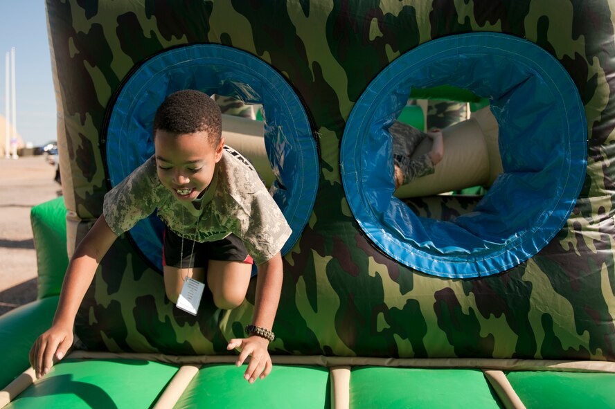 Cassius Withers Jr., age 8, son of Senior Airman Aaron Norfleet, 56th Communications Squadron, conquers the blow up confidence course at the sixth annual Operation Kids event at Luke Air Force Base, Arizona, Oct. 25, 2014. Operation Kids is a simulated deployed exercise for kids to help them understand the things their parents do when preparing for a deployment and what it’s like to be in a deployed environment. (U.S. Air Force photo by Staff Sgt. Staci Miller)
