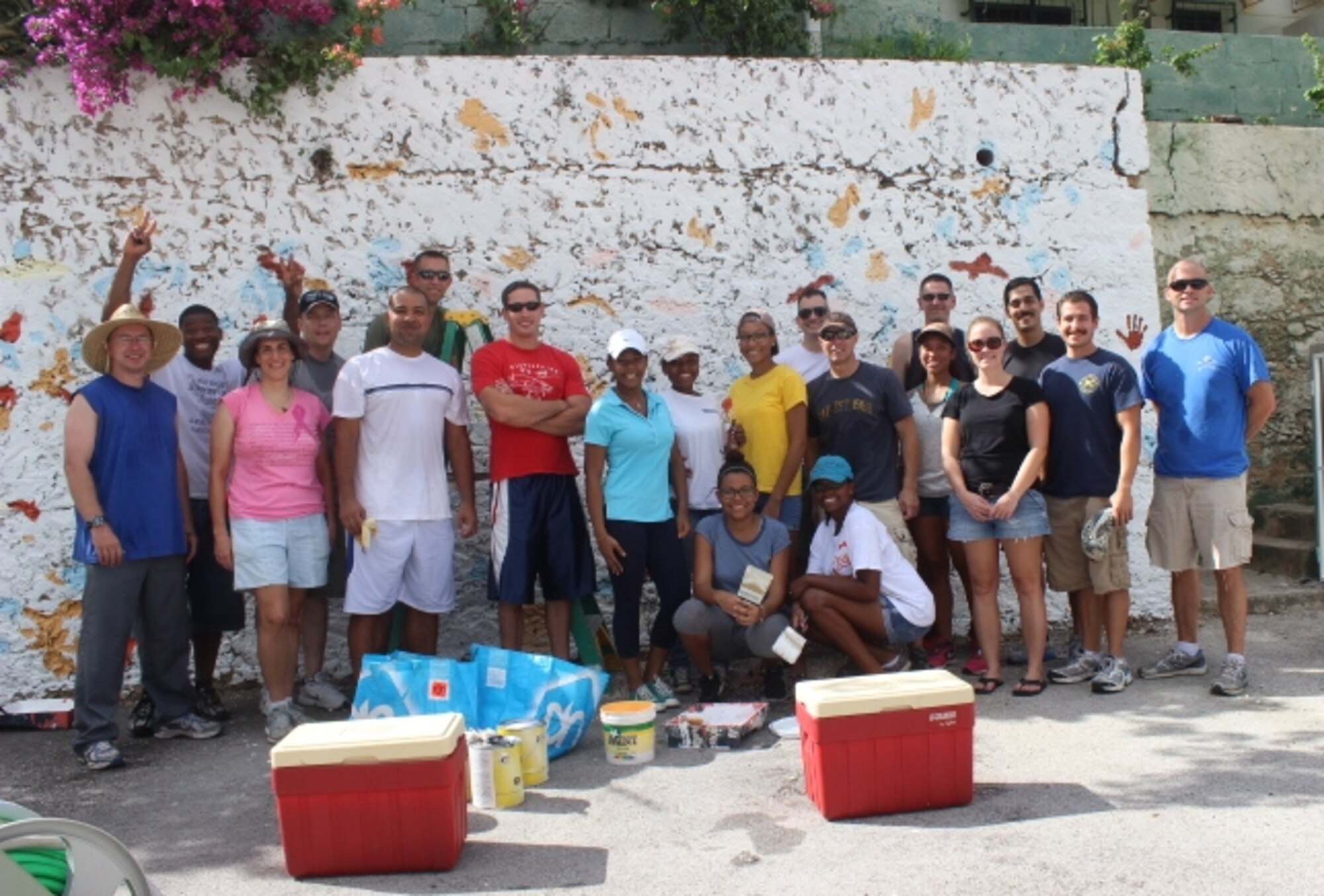 Fifteen Airmen from the U.S. Forward Operating Location pause for a photo while revitalizing the Kas Broeder Pius Women’s and Children’s Shelter, Oct. 25, 2014. The Airmen partnered with six local high school students and their families to paint the compound walls and clear debris in order to enhance the living space for residents. Kas Broeder Pius provides a safe living environment for teenage women who are pregnant or have small children. Members of the USFOL look for volunteer opportunities to demonstrate their long standing appreciation for the hospitality they receive from the citizens of Curacao. (Courtesy Photo)