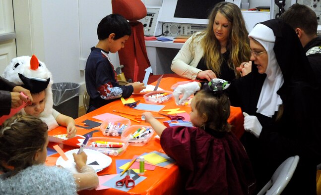 Children and volunteers create Jack-O-Lantern masks  Oct. 24 during the Warren ICBM and Heritage Museum's "Night at the Museum." The museum offered a number of activities for children, including a scavenger hunt, a trivia contest and a costume contest.  (U.S. Air Force photo by Airman 1st Class Brandon Valle)
