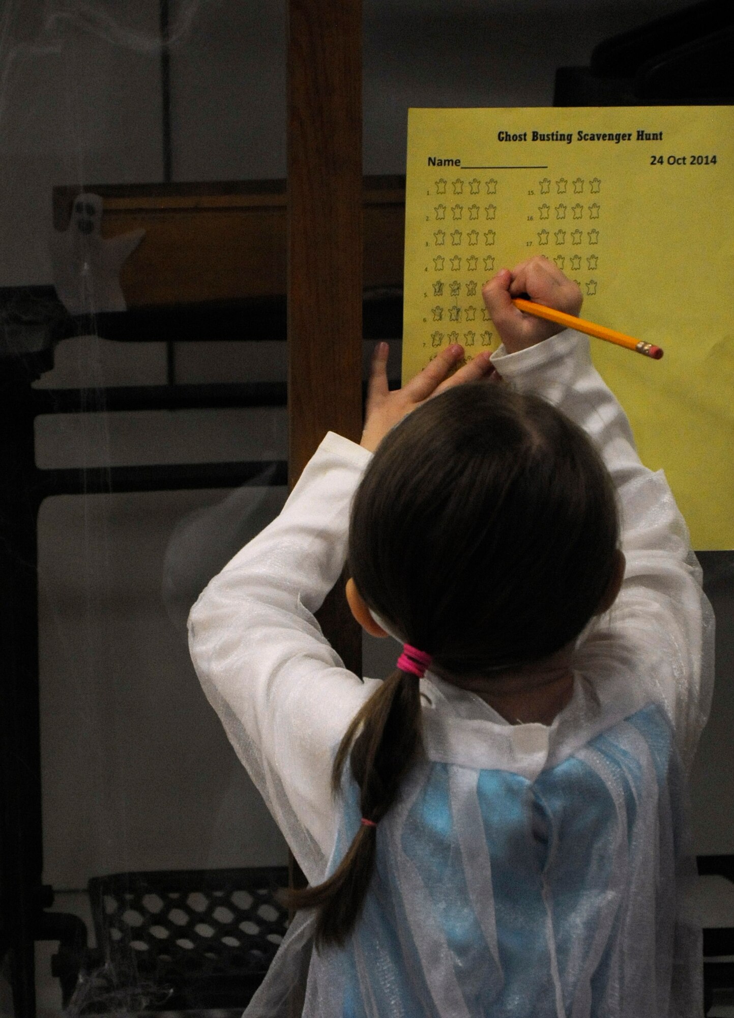 Aurora, 4, daughter of Capt. Eric Ledwon, 90th Operation Support Squadron, marks off the number of ghosts inside a display case Oct. 24 during the "Ghost Busting" scavenger hunt for the Warren ICBM and Heritage Museum's "Night at the Museum." Children who found all the ghosts in the museum were awarded special ghost-buster dog tags. (U.S. Air Force photo by Airman 1st Class Brandon Valle)
