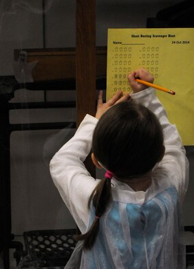 Aurora, 4, daughter of Capt. Eric Ledwon, 90th Operation Support Squadron, marks off the number of ghosts inside a display case Oct. 24 during the "Ghost Busting" scavenger hunt for the Warren ICBM and Heritage Museum's "Night at the Museum." Children who found all the ghosts in the museum were awarded special ghost-buster dog tags. (U.S. Air Force photo by Airman 1st Class Brandon Valle)
