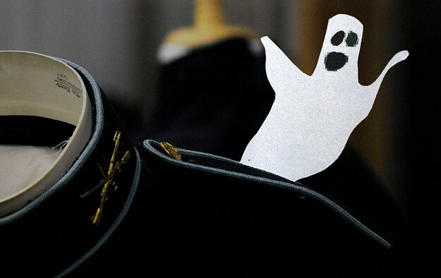 A "ghost" peeks out form behind a period-style uniform located in one of the exhibits of the Warren ICBM and Heritage Museum Oct. 24. Ghosts were placed in various exhibits throughout the museum for children to find during a "Ghost Busting" scavenger hunt. (U.S. Air Force photo by Airman 1st Class Brandon Valle)
