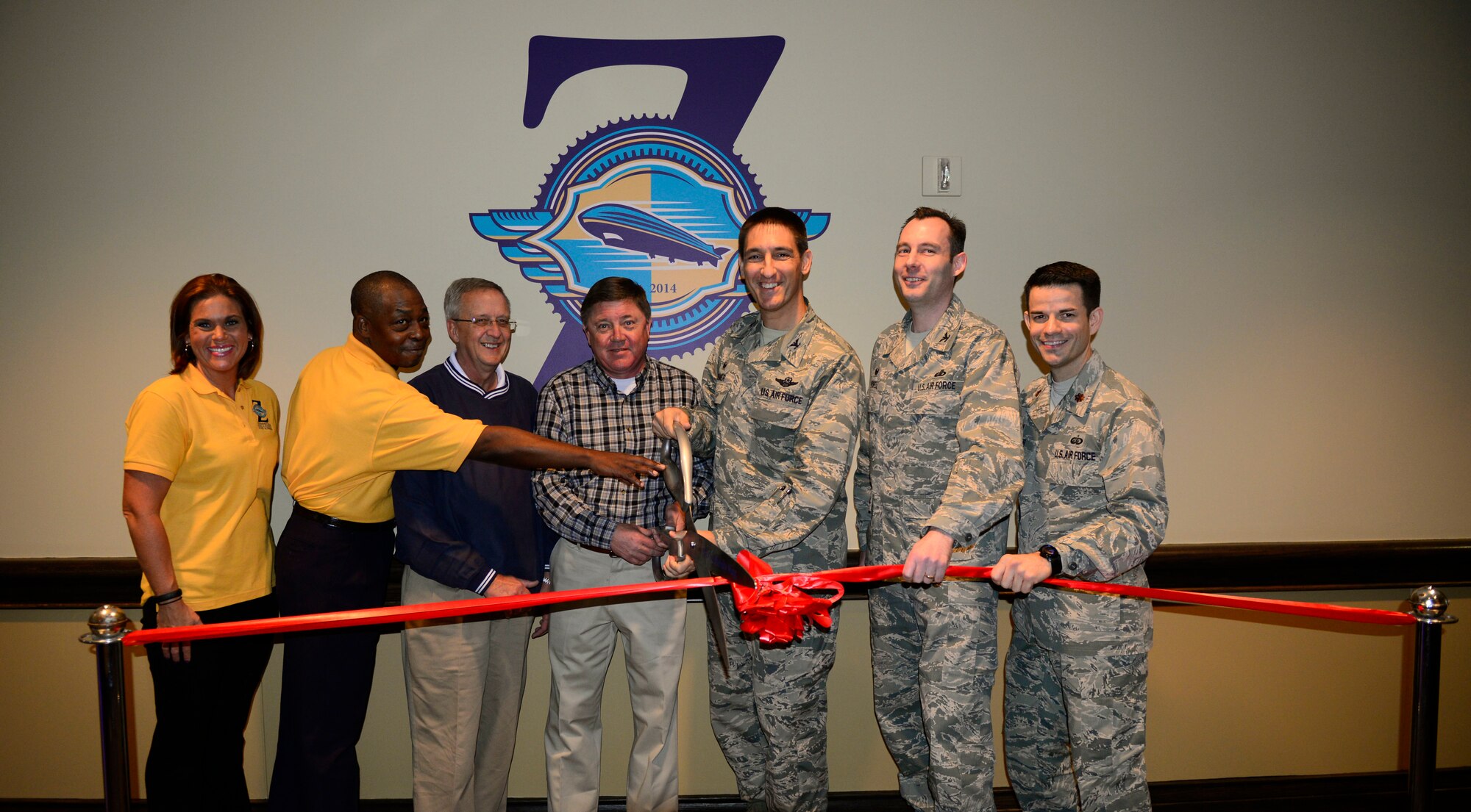 (left to right) Zeppelins staff, the construction contractors, Col. Kyle Kremer, the 375th Air Mobility Wing Commander and 375th Mission Support Group Commander and Force Support Squadron Commander cut the ribbon at the Grand Opening of Zeppelins, Oct. 22, 2014. (U.S. Air Force photo/ Staff Sgt. Stephenie Wade)