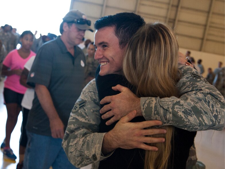 An Airman from the 824th Base Defense Squadron embraces a loved one after returning from a deployment Oct. 26, 2014, at Moody Air Force Base, Ga. The Airman was one of more than 100 members from the 824th BDS who returned to Moody after a six-month deployment to Southwest Asia. (U.S. Air Force photo by Airman 1st Class Dillian Bamman/Released)