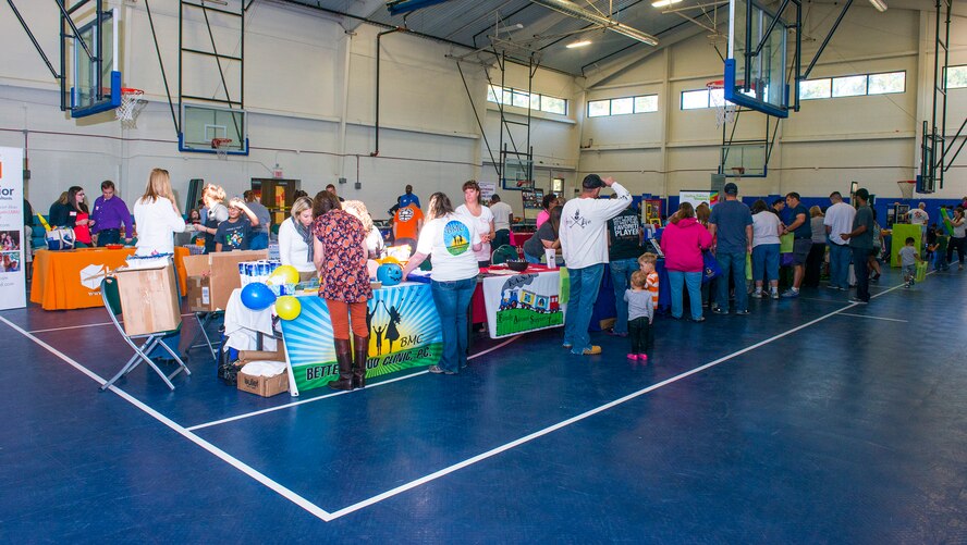 Team Moody members listen to the different vendors about their various programs during the 4th Annual Child Expo Oct. 25, 2014, at Moody Air Force Base, Ga. The expo hosted 35 vendors and they all provided information about their organization as well as a carnival game for the children to play. (U.S. Air Force photo by Airman 1st Class Ceaira Tinsley/Released)