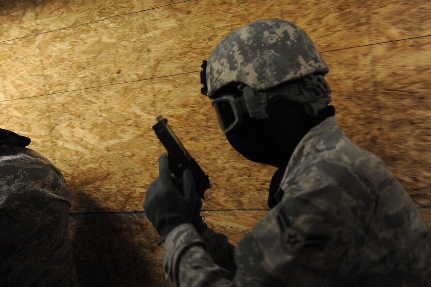 U.S. Air Force Airmen assigned to the 20th Security Forces Squadron sweep down a hallway in search of a simulated active shooter during a training session at Shaw Air Force Base, S.C., Oct. 22, 2014. During the training Airmen had to enter the building in three-man and four-man teams, break down a metal door, apprehend an active shooter, and rescue hostages inside. (U.S. Air Force photo by Airman 1st Class Michael Cossaboom/Released)