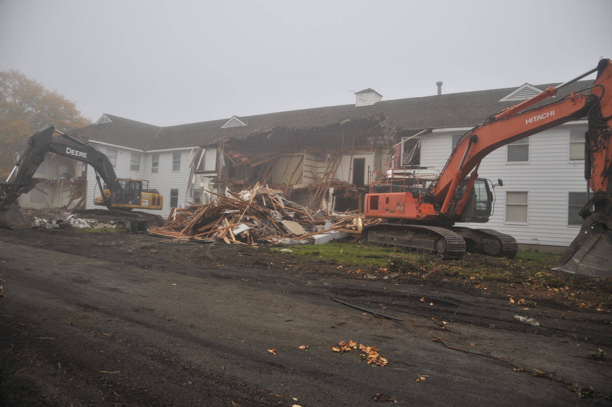 Contractors pause after beginning the demolition on the previous installation headquarters building, also known as the "White House," Oct. 27, 2014 at Fairchild Air Force Base, Wash. The building was built in 1943 and originally served as the headquarters for the newly formed Spokane Army Air Depot during World War II. (U.S. Air Force photo/Senior Airman Mary O'Dell)