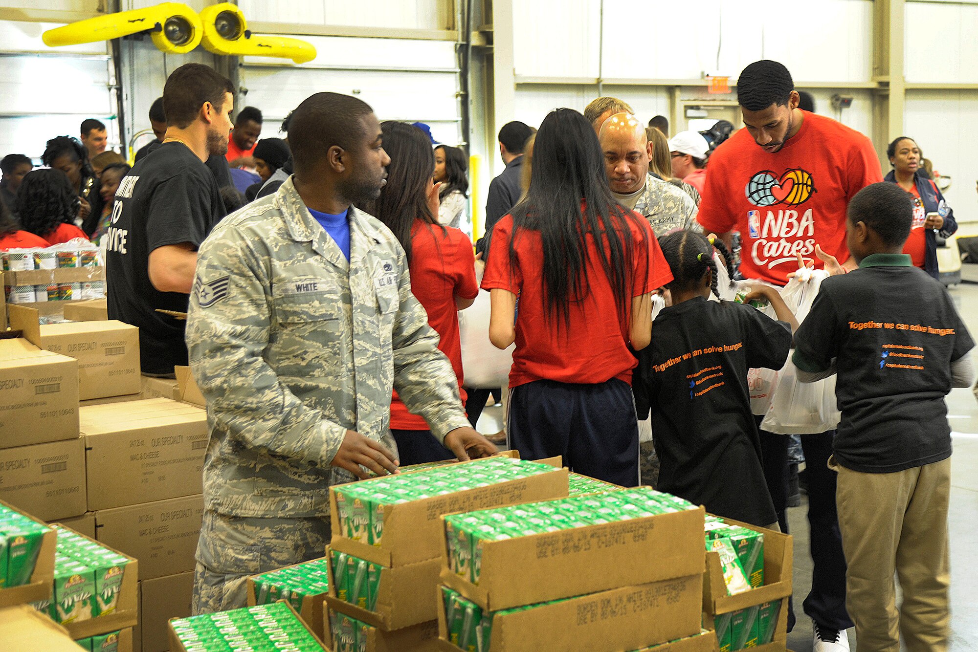 Staff Sgt. Thomas White, Air Force District of Washington unit training manager, unpacks juice for donation bags at the Capital Area Food Bank in Washington, D.C., Oct. 24, 2014. As part of NBA Cares and the league’s commitment to service, members of the Washington Wizards teamed up with military personnel and local students from Browne Education Campus to help pack bags for the Capital Area Food Bank’s Weekend Bag Program. (U.S. Air Force photo/Mike Martin)