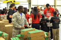 Staff Sgt. Thomas White, Air Force District of Washington unit training manager, unpacks juice for donation bags at the Capital Area Food Bank in Washington, D.C., Oct. 24, 2014. As part of NBA Cares and the league’s commitment to service, members of the Washington Wizards teamed up with military personnel and local students from Browne Education Campus to help pack bags for the Capital Area Food Bank’s Weekend Bag Program. (U.S. Air Force photo/Mike Martin)