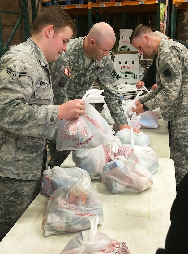 Airman 1st Class Brent Christensen, 11th Wing Command Post, ties and packs bags for the Capital Area Food Bank’s Weekend Bag Program at the Capital Area Food Bank in Washington, D.C., Oct. 24, 2014. As part of the NBA Cares and the league’s Commitment to Service initiative, Washington Wizards coaches and players teamed up with service members to help the food bank ensure nearly 2,000 children had food to eat during the weekend when they didn’t have access to school meals. (U.S. Air Force photo/Mike Martin)
