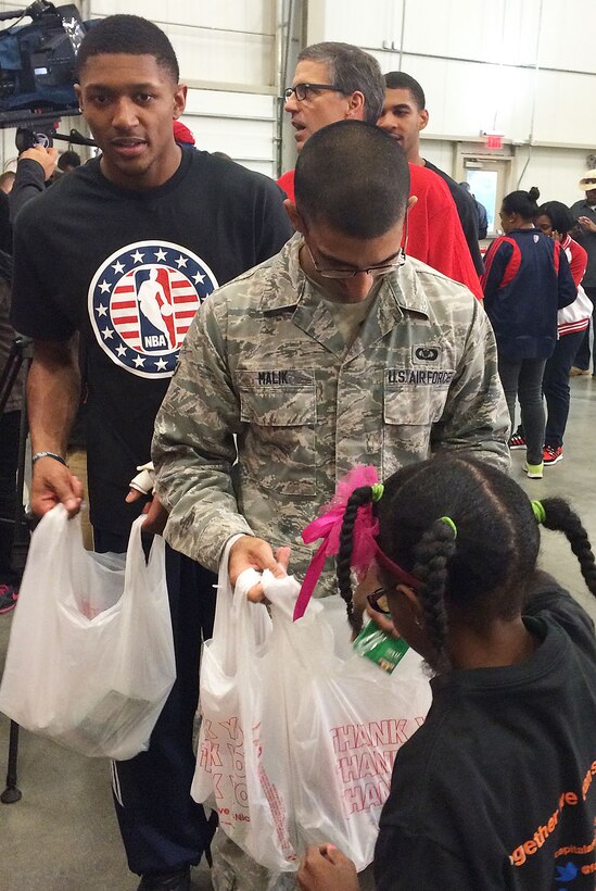 Airman 1st Class Zane Malik, 11th Wing Command Post, and Washington Wizards’ Guard Bradley Beal wait in line for a volunteer from Browne Education Campus to fill bags with food for the Capital Area Food Bank’s Weekend Bag Program at the Capital Area Food Bank in Washington, D.C., Oct 24, 2014. According to a study by the Capital Area Food Bank and Feeding America, hunger in the Washington metro area increased by 11 percent in the last four years. (U.S. Air Force photo/Mike Martin)