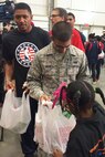 Airman 1st Class Zane Malik, 11th Wing Command Post, and Washington Wizards’ Guard Bradley Beal wait in line for a volunteer from Browne Education Campus to fill bags with food for the Capital Area Food Bank’s Weekend Bag Program at the Capital Area Food Bank in Washington, D.C., Oct 24, 2014. According to a study by the Capital Area Food Bank and Feeding America, hunger in the Washington metro area increased by 11 percent in the last four years. (U.S. Air Force photo/Mike Martin)