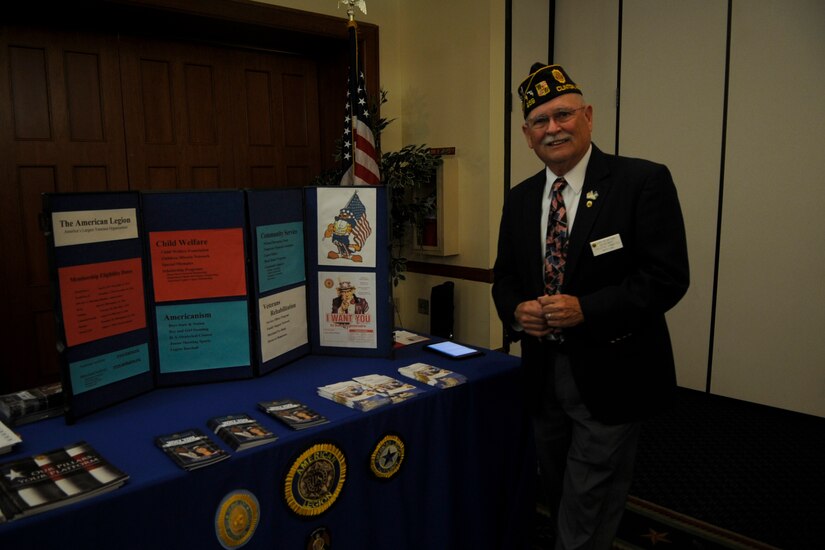 Gary Gifford, The American Legion Clinton Post 259 1st Vice commander, poses with the American Legion stand during the Joint Base Andrews and Anacostia Bolling Retiree Appreciation Day at The Club on JBA, Maryland, Oct. 25, 2014. Gifford, along with vendors from the JBA Exchange, Andrews Federal Credit Union, John Hopkins Family Health Plan and Washington Area Spouses’ Club provided information and opportunities to local retirees. (U.S. Air Force photo/ Senior Airman Nesha Humes)