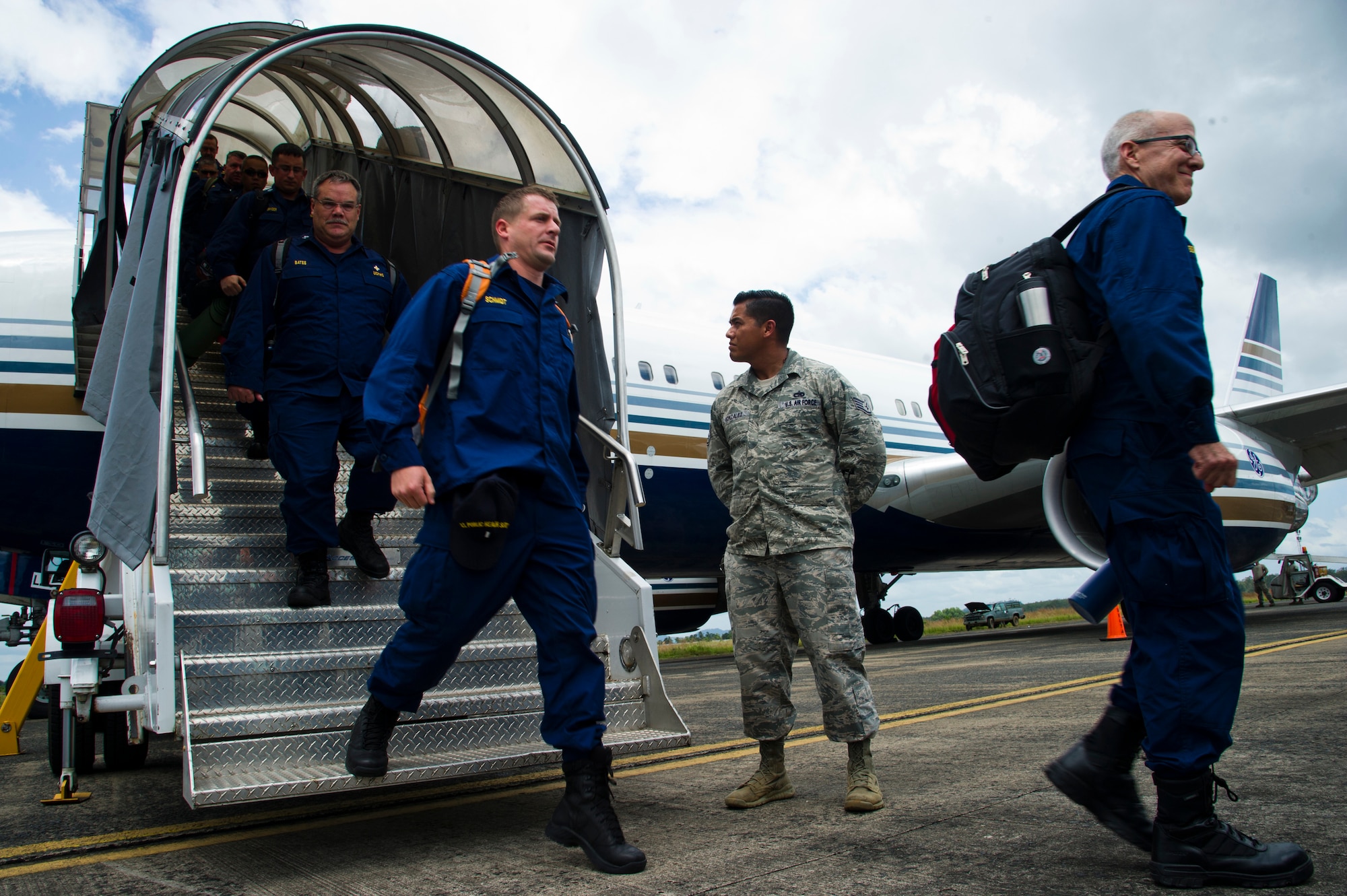 ROBERTS INTERNATIONAL AIRPORT, Republic of Liberia - U.S. Air Force Staff Sgt. Daniel Gonzalez, an aerial porter with the Joint Task Force-Port Opening team of the 621st Contingency Response Wing stationed at Joint Base McGuire-Dix-Lakehurst, N.J., escorts members of the U.S. Public Health Service as they arrive here, during Operation UNITED ASSISTANCE, October 27, 2014. The medical staff of the USPHS will aid Ebola patient medical staff who need medical care. OUA is a U.S. Africa Command-led operation to provide command and control, logistics, training and engineering support to the U.S. government’s efforts to contain the Ebola virus outbreak in West African nations. (U.S. Air Force photo/Staff Sgt. Gustavo Gonzalez/RELEASED)