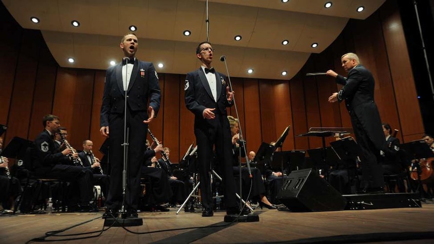 Col. Larry Lang conducts Tech. Sgt. Daniel Anderson and Master Sgt. Matthew Irish as they sing a duet during The U.S. Air Force Band Concert Band’s final performance during its 2014 Spring Tour at Michigan State University in East Lansing, Mich., April 13, 2014. Ceremonial support is one of three core mission sets that AFDW is responsible for. This support can vary from participating in National Special Security Events such as the State of the Union Address or Presidential Inaugurations to providing official honors during funerals at Arlington National Cemetery.  (U.S. Air Force photo/Master Sgt. Tammie Moore)