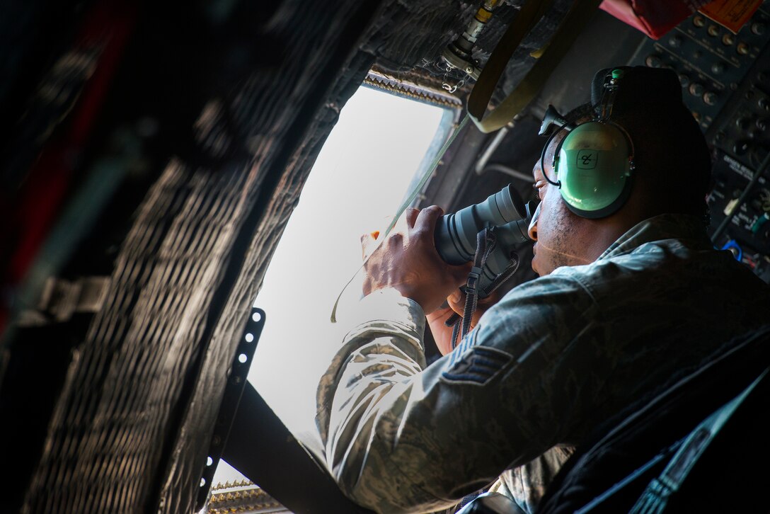U.S. Air Force Staff Sgt. Rainair Howard, 723d Aircraft Maintenance Squadron aerospace propulsion journeyman, scans the valley floor from the window of an HC-130P Combat King in search of a downed Air National Guard F-15C Eagle pilot Aug. 28, 2014, in the skies over the Shenandoah Valley, Va. The pilot was assigned to the 104th Fighter Wing at Barnes Air National Guard Base, Mass. (U.S. Air Force photo by Airman 1st Class Ryan Callaghan/Released)