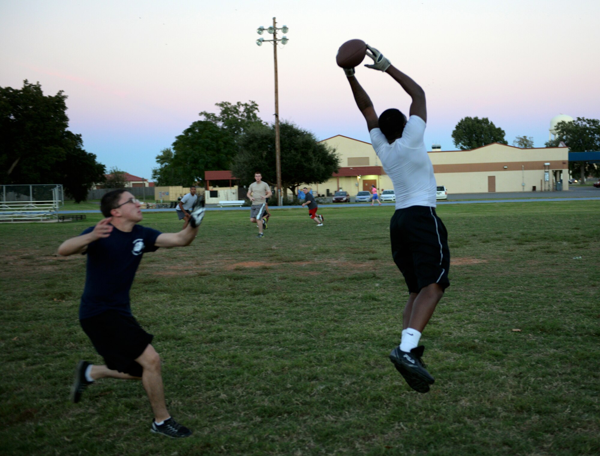 Senior Airman Chad Battle, 2nd Munitions Squadron, goes airborne for a pass as Airman 1st Class Zachary Henesy, 2nd MUNS, defends at the Senior Airman Bryan R. Bell Fitness Center on Barksdale Air Force Base, La., Oct. 16, 2014. The Airmen from 2nd MUNS are practicing for the upcoming intramural flag football season, which begins early November. (U.S. Air Force photo/Airman 1st Class Curt Beach)