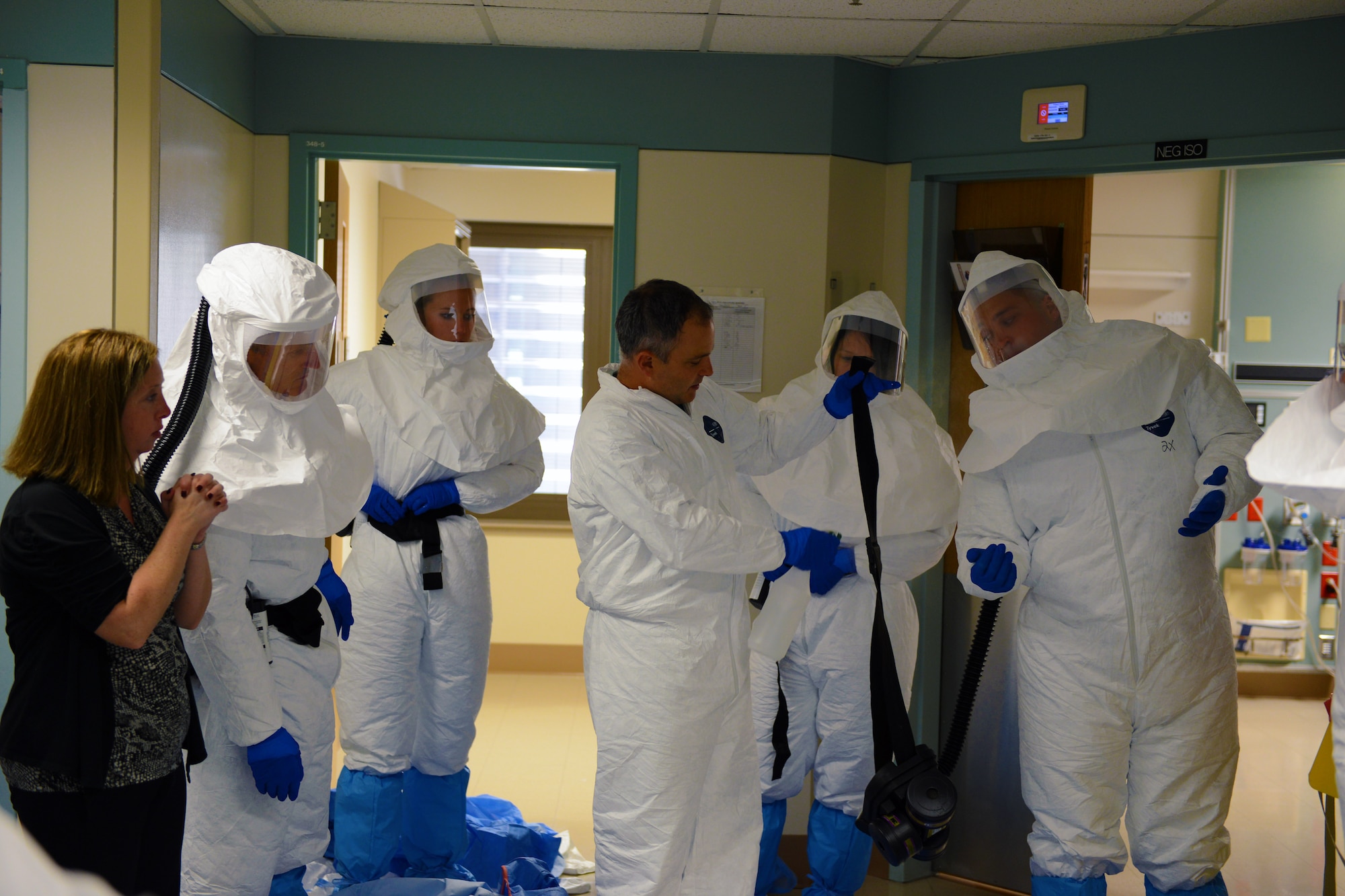 Navy Cmdr. James Lawler, center, a member of the DoD medical support team training, holds up a piece of personal protective equipment as Kristie Yeakle, far left, bio safety officer, looks on at the San Antonio Military Medical Center in San Antonio, Texas, Oct. 24, 2014. The students are part of a 30-person team designated for “prepare to deploy” status in the event of an Ebola crisis in the U.S. (DoD photo/Army Sgt. 1st Class Tyrone C. Marshall Jr.)